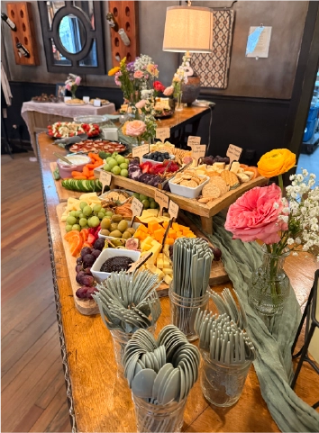 Elaborate charcuterie and grazing board spread with fresh flowers set up for a private event at the Fortin Ironworks Event Lounge in Grandview Columbus Ohio